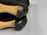 the bottom of a pair of black sued shoes on a white surface