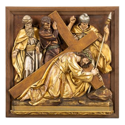 une statue de Jésus portant la croix, entouré d'autres personnes