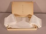 a box that has three napkins and a book in it
