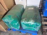 two large bags of green plastic sitting on a pallet