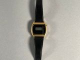 a close up of a watch on a white surface with a black strap