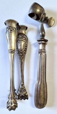 two spoons and a fork on a white surface