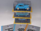 trois petites voitures bleues sont empilées les unes sur les autres dans une vitrine