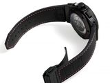 a close up of a watch on a white surface with a black strap