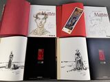 six books of comics are lined up on a table