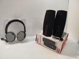 deux haut-parleurs et un casque posés sur une table