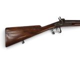 un vieux fusil avec un canon en bois et un étui en bois