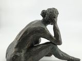 statue of a man sitting on his knees with his hand on his face