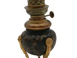 un vase noir et doré posé sur un socle, sur fond blanc
