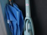 un aspirateur posé par terre à côté d'un parapluie bleu