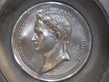 a silver plate with a picture of a woman on it
