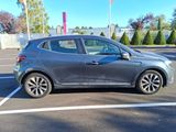 La voiture grise est garée sur le parking, la portière ouverte.