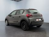 the back of a grey car is parked in a large room