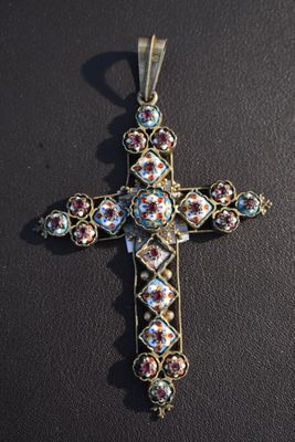 un gros plan d'une croix posée sur une table, sur fond noir