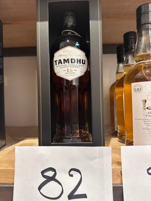 des bouteilles d'alcool exposées dans un magasin, avec leurs étiquettes de prix