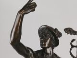 a statue of a man holding a staff and a snake