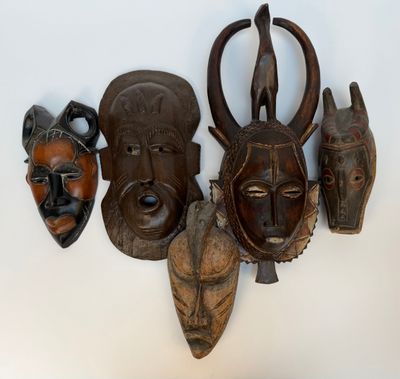 plusieurs masques africains accrochés au mur d'une pièce