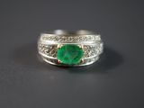Gros plan sur une bague ornée d'une pierre verte