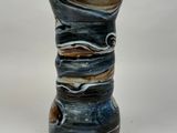 a close up of a vase on a white surface