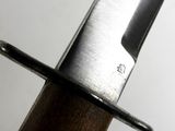 a close up of a knife on a wooden pole