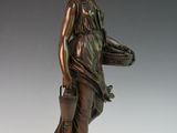 bronze statue of a woman holding a basket and a purse