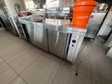un grand seau orange posé sur un plan de travail en inox