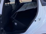 a white car with the door open in a parking lot