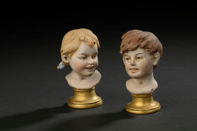 two figurines of a boy and a girl on a black surface