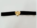 un gros plan sur un collier noir orné d'un cœur doré