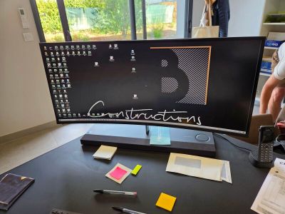 un homme debout devant un bureau d'ordinateur équipé d'un clavier et d'une souris