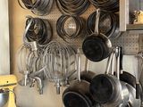 pots and pans are hanging on a wall in a kitchen