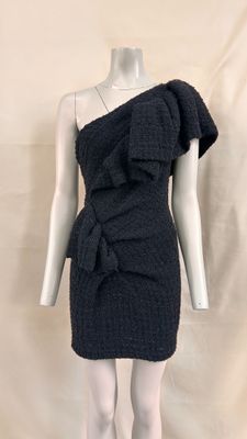 Le mannequin porte une robe noire ornée d'un nœud.