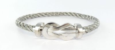 un gros plan d'un bracelet en argent orné d'un nœud