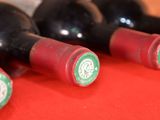 several bottles of wine are lined up on a red table
