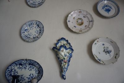 de nombreuses assiettes accrochées au mur, ornées de motifs bleus et blancs