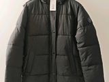 a close up of a jacket hanging on a hanger on a wall