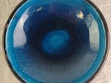 a blue bowl sitting on a table with a white table cloth
