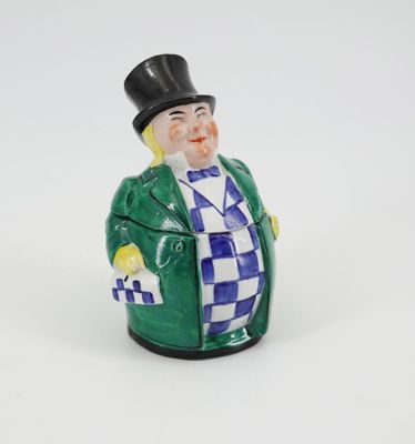 une figurine représentant un homme portant un haut-de-forme et un manteau vert