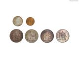 plusieurs pièces de monnaie sont disposées en ligne sur une surface blanche