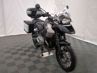 une moto qui est garée dans une pièce dont le sol est en damier