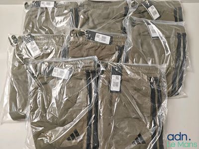 six sacs de vêtements emballés dans du plastique, posés sur une table