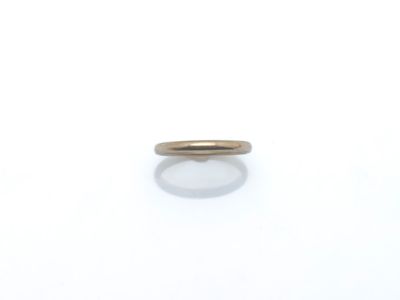 gros plan d'une bague en or sur une surface blanche