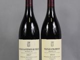 two bottles of wine sitting on top of a table next to each other