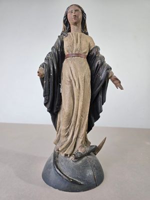 une statue représentant une femme tenant une épée, debout sur un rocher