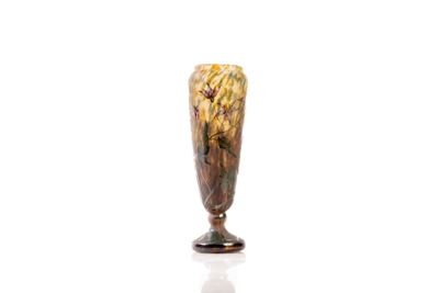 a glass vase with flowers on it on a white surface