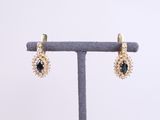 a pair of gold earrings with sapphire stones and pearls