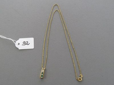 un collier en or orné d'une pierre verte et muni d'une étiquette de prix
