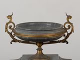 a marble bowl on a stand with a bird on it