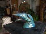 a blue bird statue on a black table in a living room