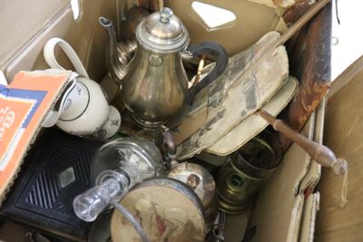 une boîte remplie de vieux objets, posée par terre